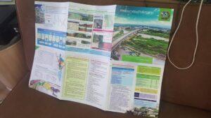 การนำเสนอโครงการวิจัยและแผนพัฒนาพื้นที่เกษตรกรรมหลายแผ่นเรียงบนโต๊ะสีน้ำตาล