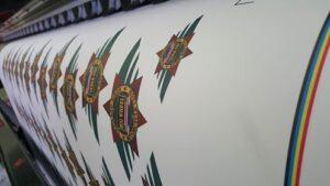 ลายตัวอักษรและการออกแบบตกแต่งแนวตั้งบนพื้นผิวสีขาว โดยมีสีทองและสีเขียวเป็นสีหลัก