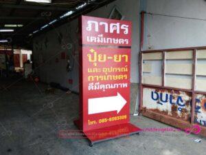 ป้ายบอกทางสีแดงขนาดใหญ่ของศาสตร์เคมีเทษฐร วางอยู่ในโรงแรมหรืออาคารที่มีผนังสีเทา