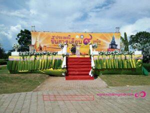 เวทีประเพณีชั้นสถาปัตยกรรมไทยตกแต่งด้วยดอกไม้สีเหลืองและสีขาว มีพื้นที่นั่งแดงและพื้นรองพื้นอิฐสีแดง