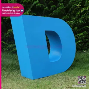 ตัวอักษร 3 มิติสีน้ำเงินขนาดใหญ่ "d" แสดงบนพื้นหลังหญ้า