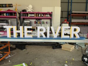 ป้ายอักษรไฟออกหลัง The River ตัวอักษร 3D สีขาวขอบเหลือง