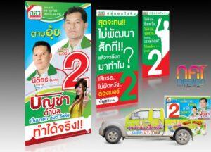 โฆษณาครบครัวประกอบด้วยแผ่นพับสีเขียวและสีฟ้า, รถตู้เหลืองขาว, และภาพชายหญิงหลายคน สำหรับแคมเปญการตลาดไทย