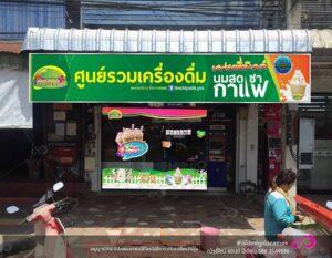 ร้านน้ำนมสดไทยชื่อ Fresh Milk ยิ่ม ด้านหน้าอาคารสีเขียวและสีส้ม ตกแต่งด้วยโลโก้และรูปไอศครีม พร้อมป้ายลวดลายสัตว์ที่น่ารักที่หน้าร้าน
