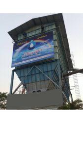 หอเก็บน้ำสูงโลหะสีฟ้ามีป้ายโฆษณาขนาดใหญ่ติดตั้งด้านข้าง