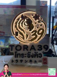 ป้ายไฟออกหลัง 3D สีทอง โลโก้เสือ TORA39 พร้อมตัวอักษรสีดำ รองหลังพลาสวูดขาว