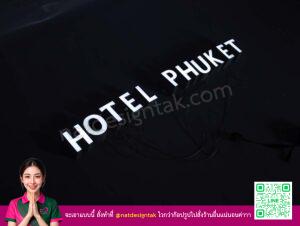 ป้ายไฟตัวอักษร Hotel Phuket สีขาวสว่างบนพื้นหลังสีดำ