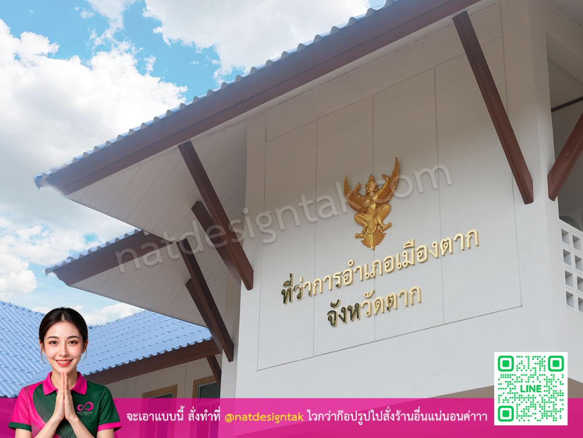 ป้ายบ้านเรือนไทยพร้อมตัวอักษรสีทองและครุฑ